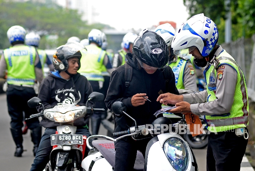 Petugas polisi melakukan tilang terhadap pelangar lalu lintas (ilustrasi)