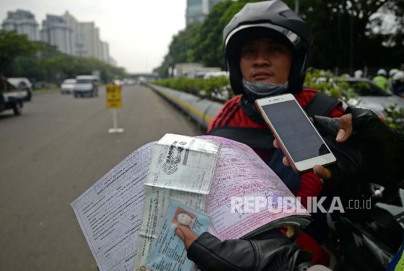 Petugas polisi melakukan penindakan terhadap pelanggar lalu lintas dengan mengunakan sistem E-Tilang saat razia kendaraan bermotor di Kawasan Kemayoran, Jakarta, Rabu (11/1). 