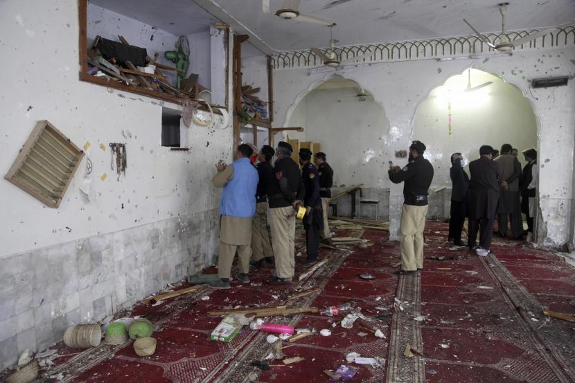 Petugas polisi memeriksa lokasi ledakan bom di dalam sebuah masjid di Peshawar, Pakistan, Jumat, 4 Maret 2022. 