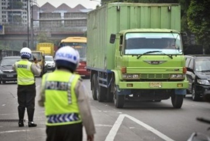 Petugas Polisi mengatur lalu lintas truk di pintu masuk Tol, jalan S. Parman, Kebon Jeruk, Jakarta Barat.