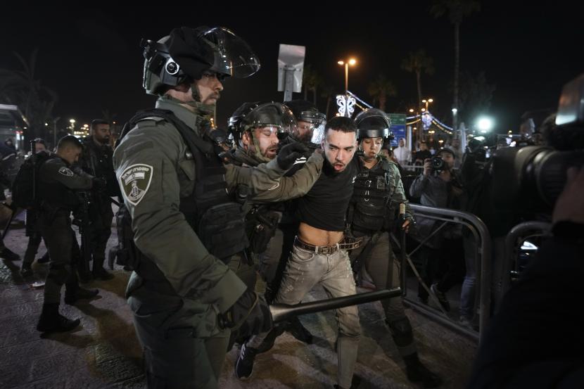 Petugas polisi perbatasan Israel menahan seorang pengunjuk rasa selama bentrokan antara pasukan keamanan Israel dan warga Palestina di sebelah Gerbang Damaskus, di luar Kota Tua Yerusalem, selama bulan suci Ramadhan, Senin, 4 April 2022.