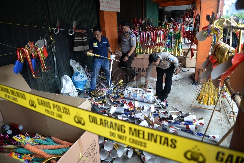 Petugas polisi Polsek Taman Sari mengamankan terompet yang terbuat dari kertas sampul Alquran saat razia di Jalan Gajah Mada, Jakarta, Selasa (29/12). (Republika/Yasin Habibi)
