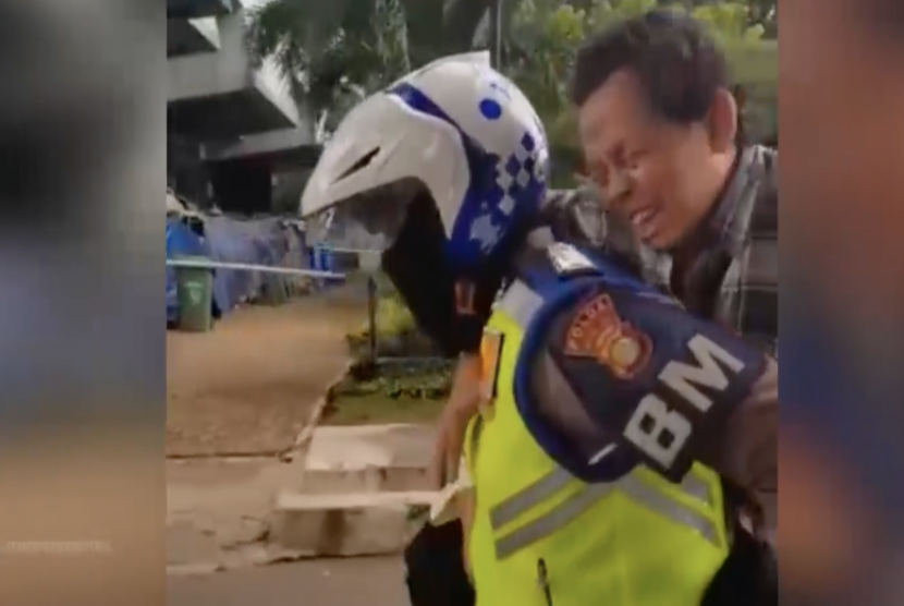 Petugas polisi tengah menolong penumpang Transjakarta yang terkena serangan jantung.