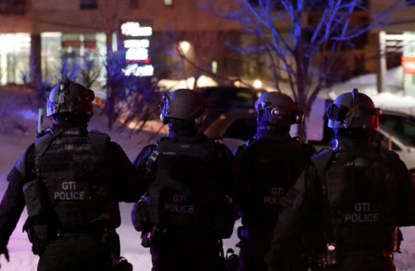 Petugas polisi tim SWAT berjalan mengelilingi masjid setelah penembakan di Kota Quebec, 29 Januari 2017.