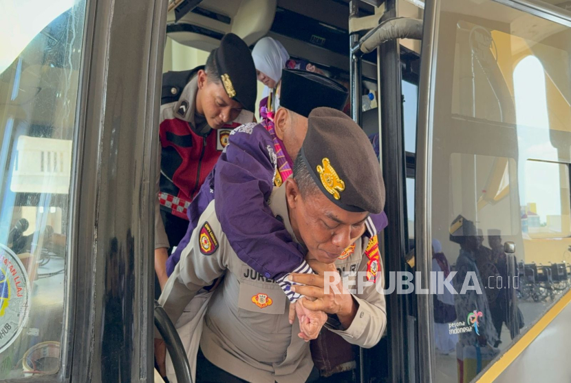Petugas Polres Indramayu membantu calhaj lansia yang tiba di  Asrama Haji Indramayu, Provinsi Jawa Barat, Kamis (1/5/2025). 