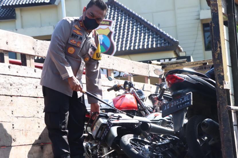 Petugas Polres Nganjuk memeriksa sepeda motor yang disita terkait aksi balap liar.