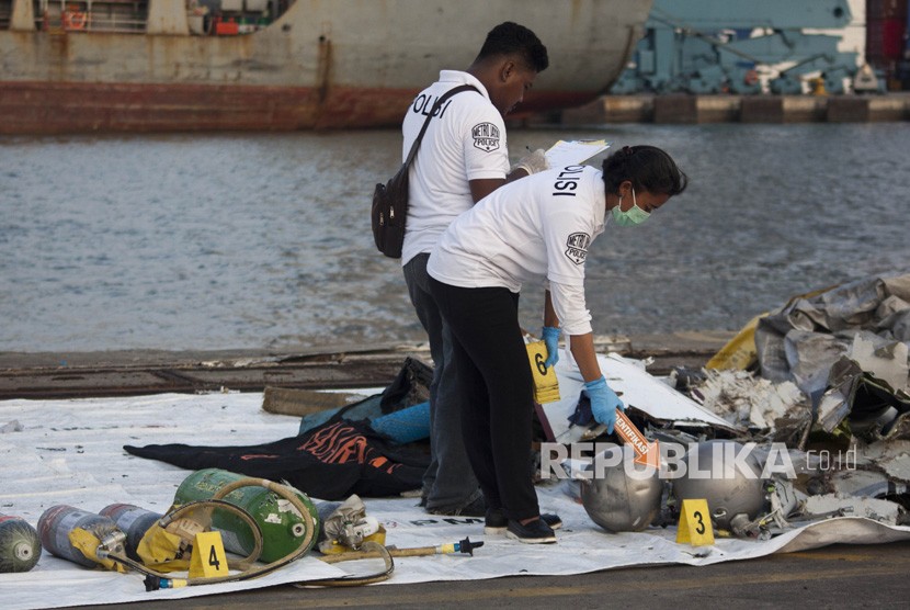 Petugas Polri melakukan identifikasi puing pesawat Lion Air JT 610 pascakecelakaan, di Pelabuhan Tanjung Priok, Jakarta, Senin (29/10/2018).