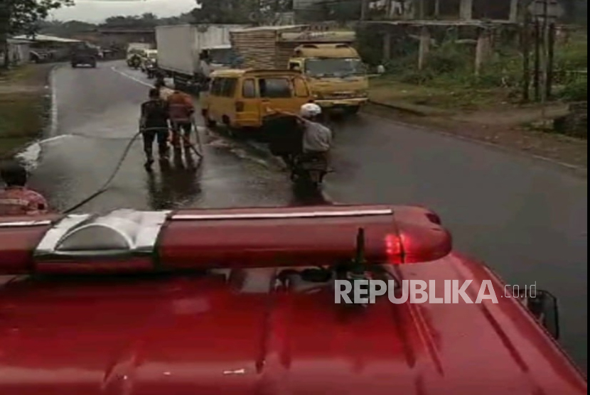 Petugas Polsek Cikalongwetan bersama Dinas Pemadam Kebakaran Bandung Barat melakukan pembersihan cairan kimia yang tumpah dari truk tanki di Jalan Cikalongwetan, Selasa (24/12/2024). Akibat kejadian itu, para pengendara motor mengalami perih, kulit melepuh dan kendaraan rusak. 