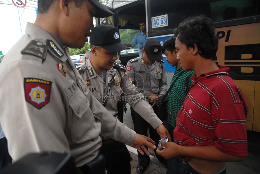 Petugas Polsek Metro Sawah Besar menertibkan sejumlah preman dan pengamen dalam razia kejahatan dalam bus di kawasan Pasar Baru, Jakarta Pusat, Rabu (13/11).   (Republika/Rakhmawaty La'lang)