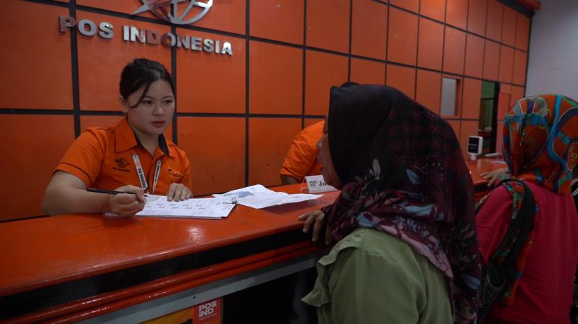 Petugas Pos Indonesia menyalurkan bantuan PKH. 