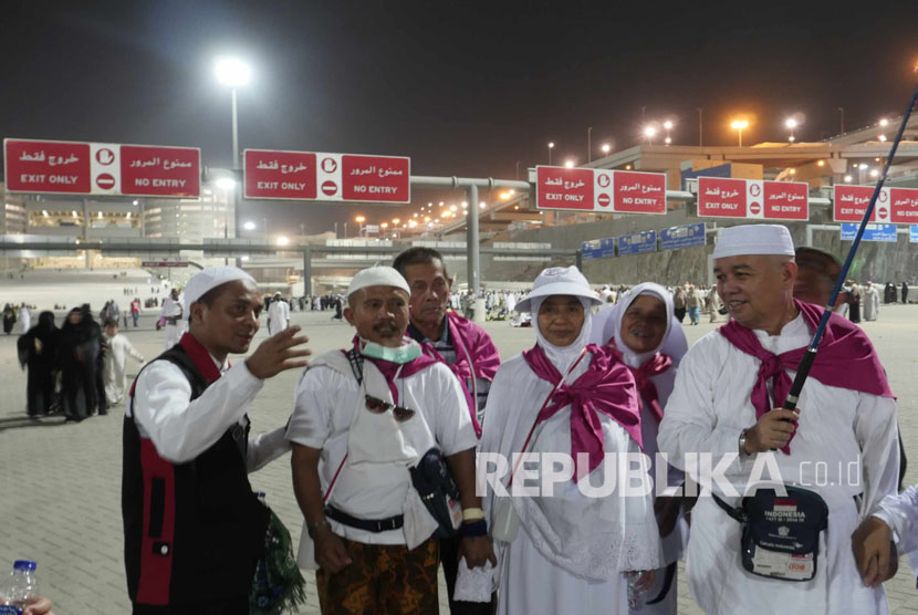 Petugas PPIH (kiri) yang terdiri dari anggota TNI dan Polri membantu mengarahkan jamaah haji Indonesia rute kembali menuju hotel di Makkah usai melontar jumrah di Mina, Selasa (13/9) dini hari. (Republika/ Amin Madani) 