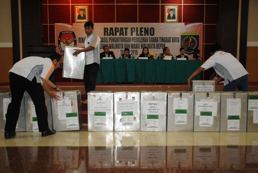 Petugas PPK membawa kotak suara dari tiap kecamatan dalam rapat pleno rekapitulasi hasil penghitungan perolehan suara tingkat kota pada Pilkada Depok di Depok, Jawa Barat, Rabu (16/12).
