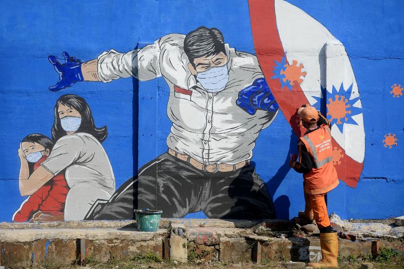 Petugas PPSU Bukit Duri menyelesaikan pembuatan mural yang berisi pesan waspada penyebaran virus Corona di Bukit Duri, Jakarta.