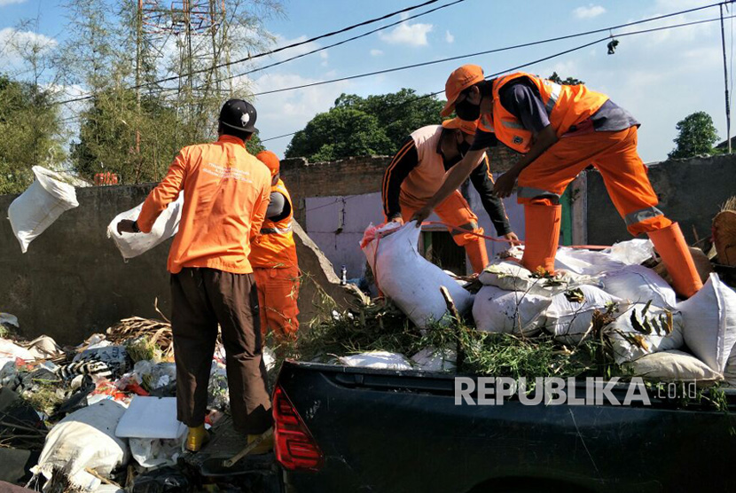 Petugas sedang membuang sampah ke tempat penampungan sampah sementara (ilustrasi) 