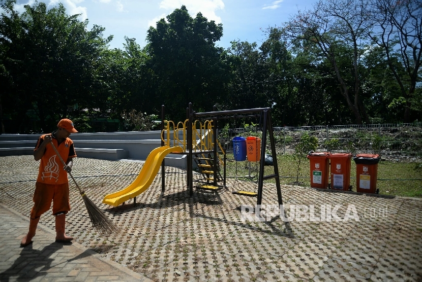 Petugas PPSU membersihkan area ruang publik terpadu ramah anak (RPTRA) Teratai yang baru selesai pembangunannya, Tebet Timur, Jakarta, Selasa (20/12)