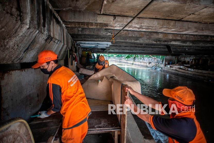 Petugas PPSU menertibkan hunian liar di kolong jembatan Jalan Proklamasi, Pegangsaan, Menteng, Jakarta, Selasa (29/12/2020). Sebanyak 12 hunian liar ditertibkan oleh petugas dari Kelurahan Pegangsaan, setelah sebelumnya Menteri Sosial Tri Rismaharini melakukan sidak di kolong jembatan tersebut. A