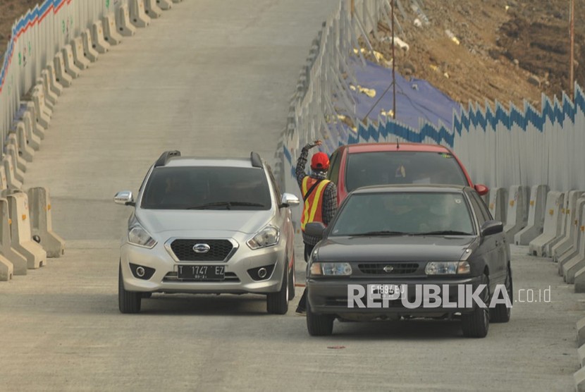 Petugas membantu sebuah mobil pemudik yang mogok akibat tidak kuat mendaki tanjakan jalur darurat jembatan Kali kenteng, di wilayah Kecamatan Susukan. ilustrasi