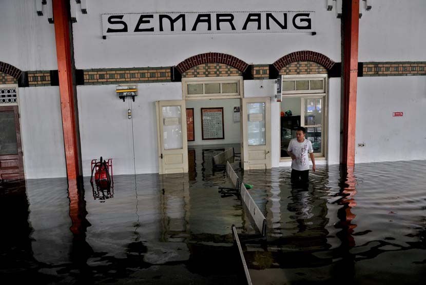  Petugas PT KAI berjalan melewati genangan air yang membanjiri Stasiun Tawang Semarang, Kamis (23/1).