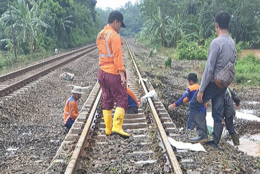 Petugas PT KAI membenahi jalur kereta api setelah terendam banjir di wilayah Ujungnegoro, Kabupaten Batang, Jawa Tengah, Ahad (27/1). Akibat banjir 11 perjalanan kereta sempat terhambat.