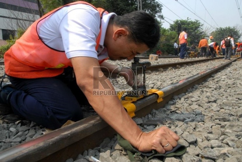   Petugas PT Kereta Api Indonesia (KAI) mengukur kerataan rel kereta api di kawasan Jatinegara,Jakarta,Kamis (6/9).   (Agung Fatma Putra)