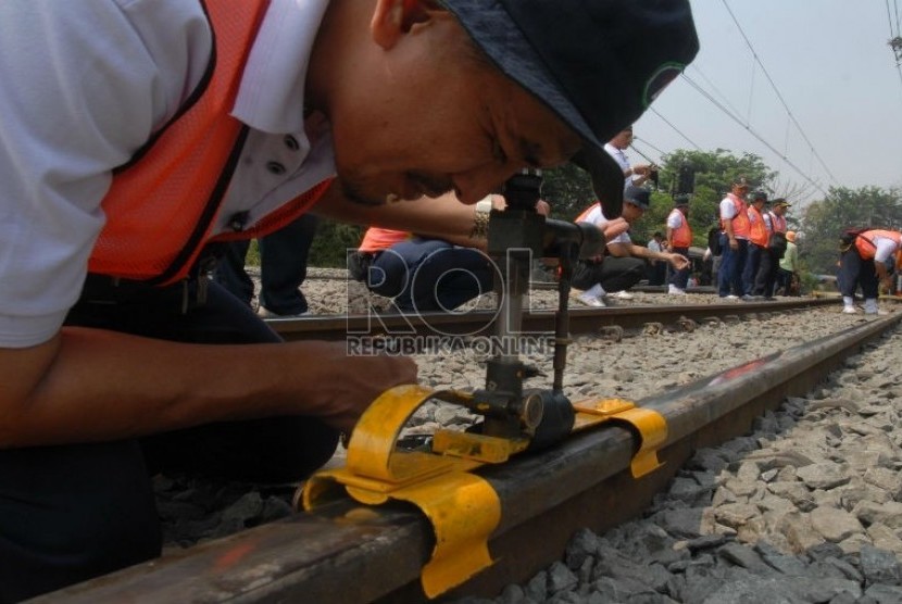   Petugas PT Kereta Api Indonesia (KAI) mengukur kerataan rel kereta api di kawasan Jatinegara,Jakarta,Kamis (6/9).   (Agung Fatma Putra)