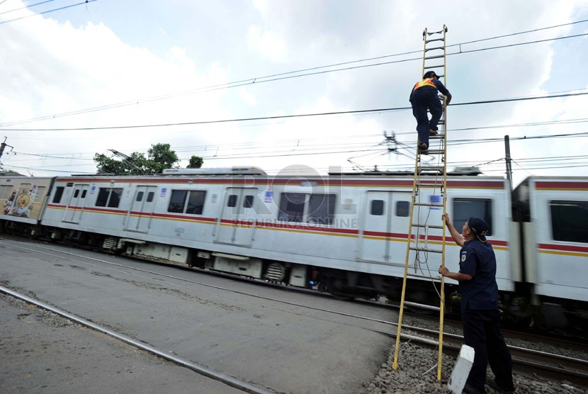   Petugas PT Kereta Api Indonesia melakukan perawatan kawat listrik di Bukit Duri, Jakarta, Senin (5/5).  (Republika/Tahta Aidilla)
