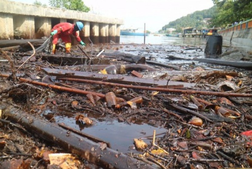Petugas PT Pertamina membersihkan sampah yang mengandung minyak di kawasan Pesisir Melawai, Balikpapan, Kaltim, Rabu (4/4). 