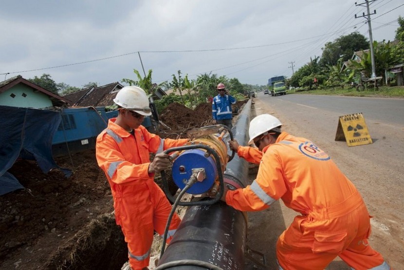 Petugas PT Perusahaan Gas Negara Tbk (PGN) sedang memasang jaringan gas. 