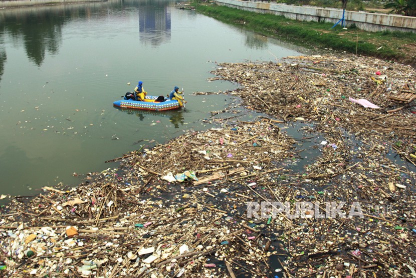Petugas mengangkut sampah-sampah yang memenuhi sungai Cisadane, di Tangerang, Banten.