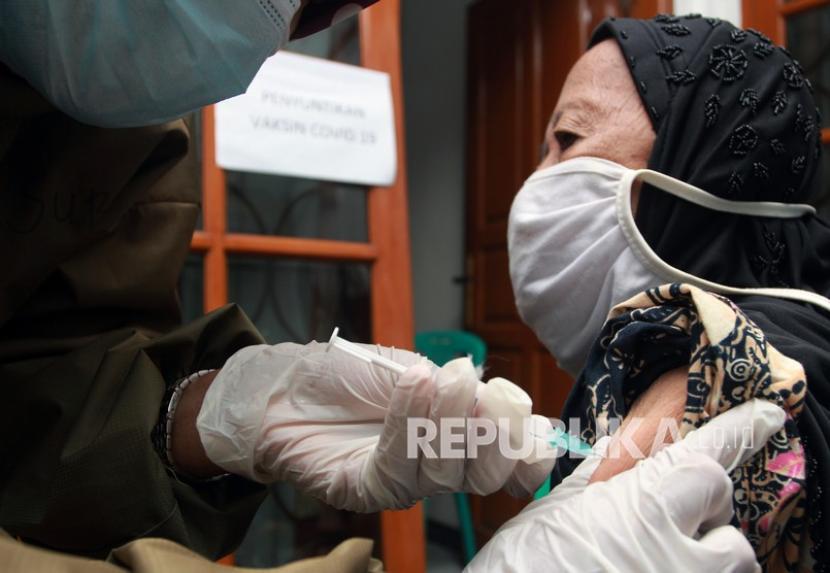 Petugas Puskesmas Kecamatan Kebayoran Lama menyuntikan vaksin COVID-19 kepada seorang warga lansia saat pelaksanaan vaksinasi COVID-19 jemput bola di rumah seorang warga Cipulir, Kebayoran Lama, Jakarta, Selasa (30/3). Vaksinasi Covid-19 lansia lambat karena sebagian kesulitan akses mendaftar vaksin