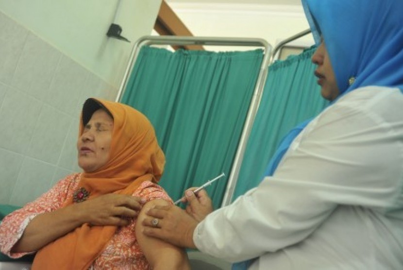 Petugas Puskesmas menyuntikkan vaksin pada salah seorang calon haji di Puskesmas Dempo Palembang, Sumsel, Selasa (28/7). Jelang keberangkatan haji pada akhir Agustus 2015, dilakukan pemeriksaan kesehatan tahap kedua yang tersebar di lima puskesmas besar Ko