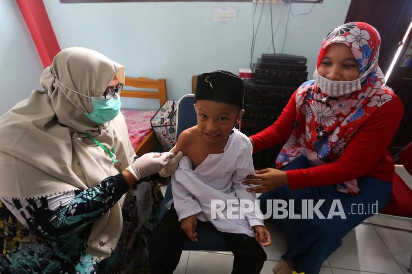 Petugas Puskesmas Ulee Kareng memberikan imunisasi pencegahan campak, difteri, dan tetanus kepada pelajar pada program Bulan Imunisasi Anak Sekolah (BIAS) di SD Negeri 42 Lamteh, Banda Aceh, Aceh, Jumat (29/10/2021). Sebanyak 1,7 juta bayi belum mendapatkan imunisasi dasar selama pandemi Covid-19.