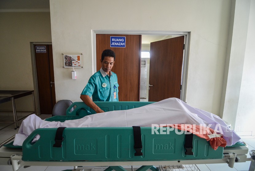 Petugas Rumah Sakit mengkafani jenazah korban minuman keras (miras) oplosan di kamar jenazah Rumah Sakit Umum Daerah (RSUD) Cicalengka, Kabupaten Bandung, Jawa Barat, Jumat (13/4).