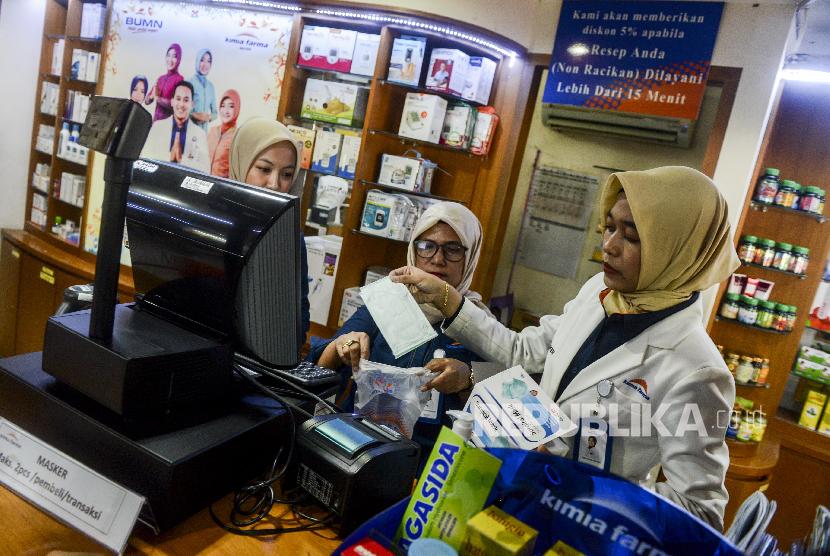 Petugas saat akan memasukan masker yang dijual ke dalam plastik di salah satu gerai apotek Kimia Farma kawasan Cikini, Jakarta, Maret lalu. Kimia Farma menggandeng Kementerian Koperasi dan UMKM untuk pasokan masker nonmedis.