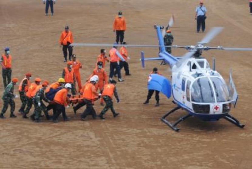 Petugas SAR dan TNI mengevakuasi jenazah korban Sukhoi ke helikopter di Helipad Lapangan Pasir Pogor, Cipelang, Cijeruk, Kabupaten Bogor, Selasa (15/5). 