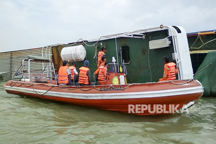 Petugas SAR Palembang memeriksa kapal Kahyong Utara yang terbalik di perairan sungai Musi, Tanjung Api Api, Banyuasin, Sumatera Selatan, Selasa (20/2). 
