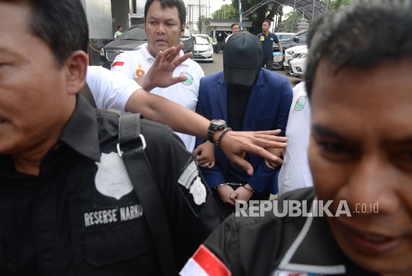 Petugas Satres Narkoba Polres Jakarta Barat membawa penyanyi dangdut Ridho Rhoma saat menjalani pemeriksaan di Balai Laboratorium Narkoba BNN, Jakarta, Senin (27/3).