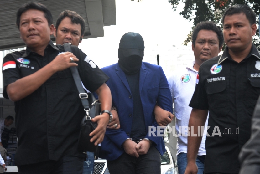 Petugas Sat Res Narkoba Polres Jakarta Barat membawa penyanyi dangdut Ridho Rhoma saat menjalani pemeriksaan di Balai Laboratorium Narkoba BNN, Jakarta, Senin (27/3).