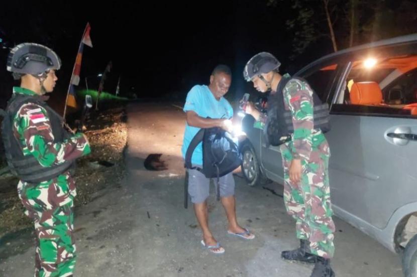 Petugas Satgas Pamtas RI-PNG RI-PNG Yonif 122/Tombak Sakti Pos Sawiyatami memeriksa pengendara yang melintas.