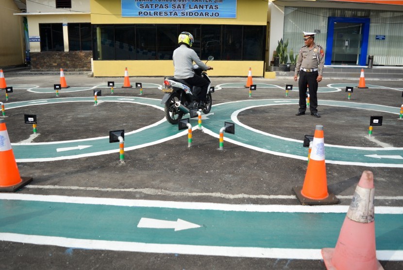 Petugas Satlantas mengawasi warga yang mengikuti ujian SIM (Surat Izin Mengemudi) C di Polresta Sidoarjo, Jawa Timur, Kamis (15/11/2018). 