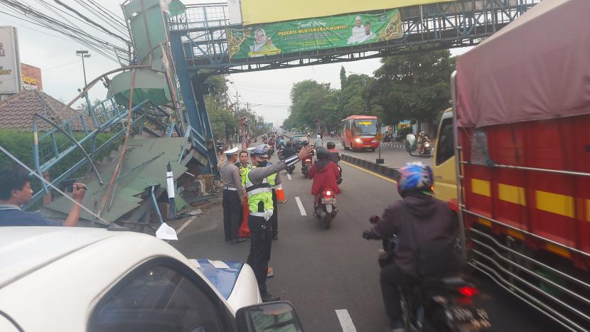  Petugas Satlantas Polres Semarang mengamankan lokasi jembatan penyeberangan orang (JPO) di Jalan Diponegoro Ungaran yang rusak berat dan miring akibat ditabrak truk.