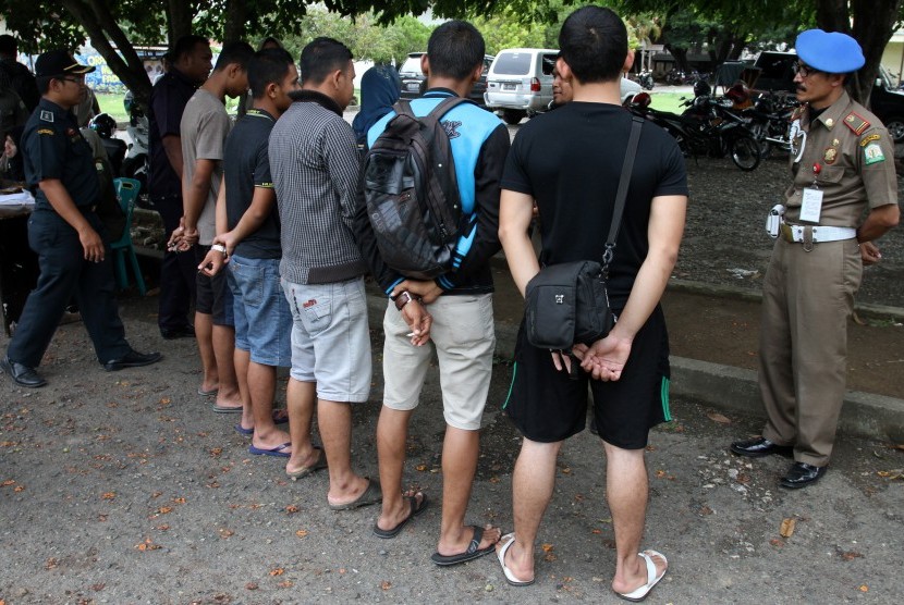 Petugas Satpol PP dan Wilayathul Hisbah (WH) memberikan pengarahan kepada warga yang terjaring razia penegakkan Syariat Islam kerena memakai celana pendek di Banda Aceh. (Ilustrasi)