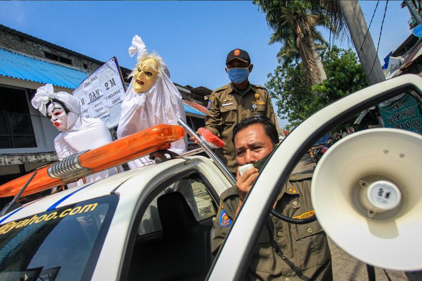 Petugas Satpol PP Kecamatan Larangan mensosialisasikan penggunaan masker dengan menggunakan kostum hantu pocong di Pasar Kreo, Kota Tangerang, Banten, Rabu (16/9/2020). Kegiatan tersebut bertujuan sebagai pengingat masyarakat untuk selalu mematuhi protokol kesehatan guna menghindari penyebaran COVID-19