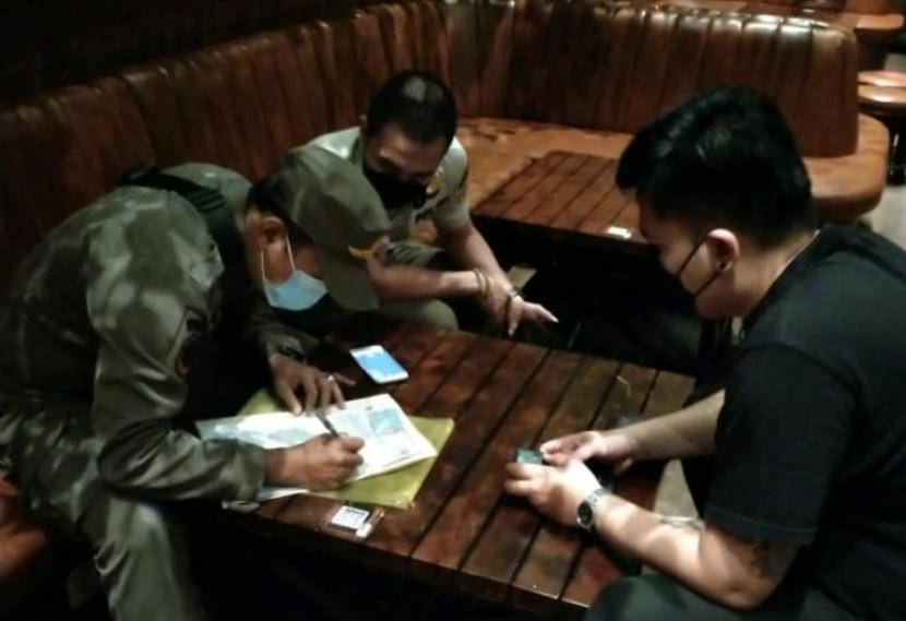 Petugas Satpol PP Kecamatan Mampang Prapatan memberi denda penutupan 3 x 24 jam kepada manajemen Bar & Resto Holywings Kemang. 