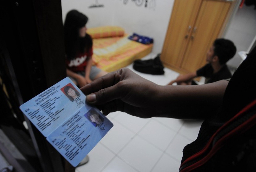 Petugas Satpol PP Kota Depok memeriksa identitas pasangan diluar nikah yang kedapatan berada dalam satu kamar saat razia di rumah kos kawasan Kelapa Dua, Depok, Jawa Barat, Selasa (12/5) malam.