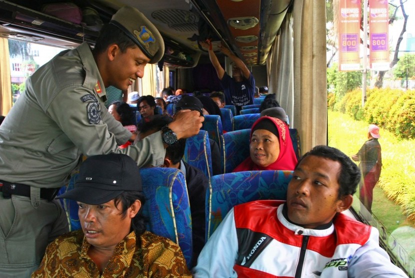 Petugas Satpol PP memeriksa kartu identitas berupa KTP penumpang bus dalam operasi Yustisi. (Ilustrasi)