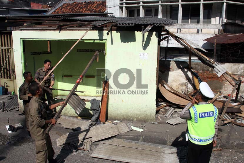  Petugas Satpol PP melakukan pembongkaran lapak PKL di kawasan Pasar Tanah Abang, Jakarta Pusat, Ahad (11/8). (Republika/ Yasin Habibi)