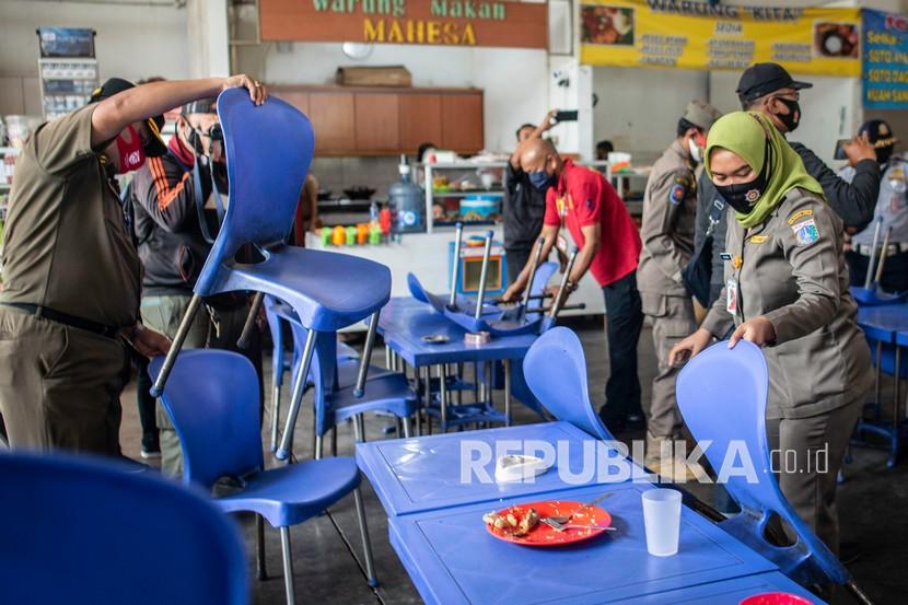 Petugas Satpol PP melakukan penertiban area kantin yang menyediakan makan di tempat saat razia penerapan Pembatasan Sosial Berskala Besar (PSBB) 