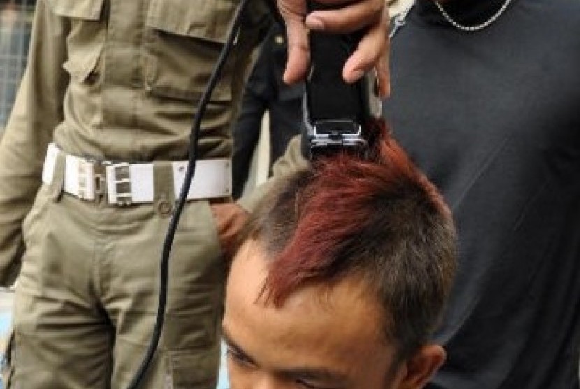Petugas Satpol PP memangkas rambut anak punk yang terjaring razia, berdasarkan laporan masyarakat (ilustrasi).