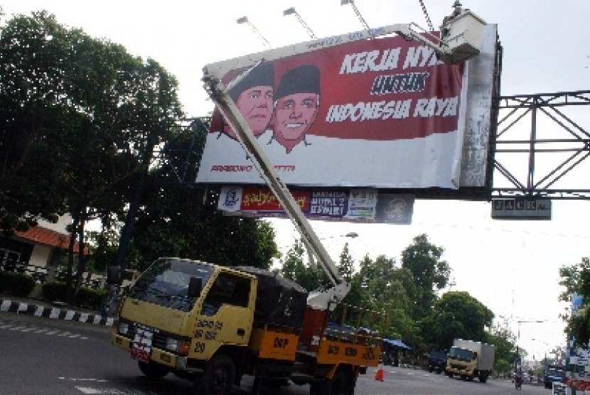 Petugas Satpol PP mencopot baliho alat peraga kampanye (APK) capres-cawapres pasangan Prabowo-Hatta di jalan A. Yani, Kota Kediri, Jawa Timur, Ahad (6/7).